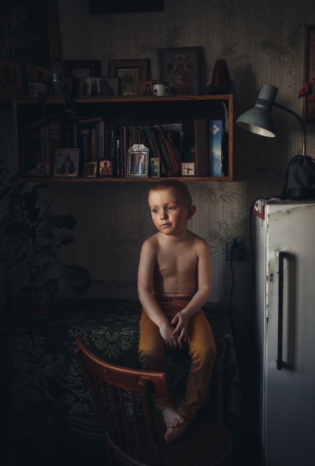 Retrato: 'Son', criança sentada em uma mesa enquanto observa o ambiente, perdido na contemplação. A fotografia mostra um outro lado da infância, de calma e reflexão — Foto: Lyudmila Sabanina (Rússia)/Sony World Photography Awards